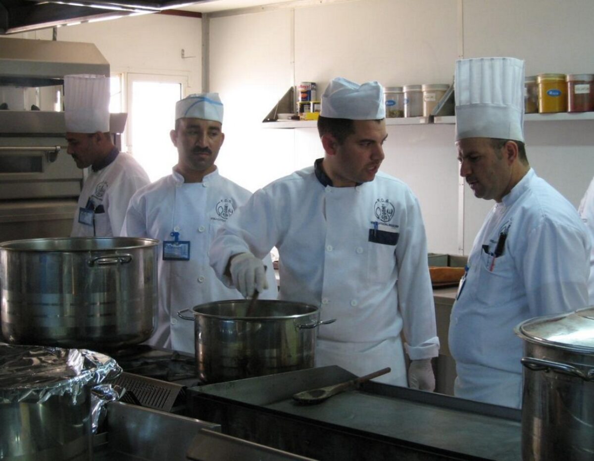 Catering team preparing meals in a field camp kitchen